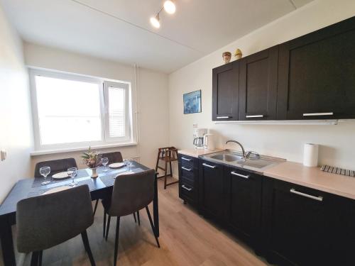 a kitchen with a table with chairs and a sink at Räpina Apartment in Räpina
