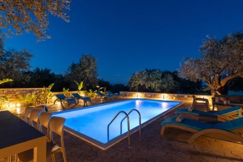 Una piscina en un patio trasero por la noche. en Villa Roi, en Kalathos