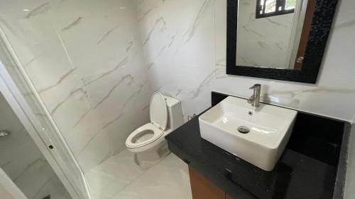 La salle de bains blanche est pourvue d'un lavabo et de toilettes. dans l'établissement Sonrisa - Golden Meadows by Hiverooms, à Cordova