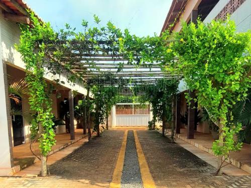 a hallway of a building with trees and vines at JACY AP GOSTOSO in São Miguel do Gostoso