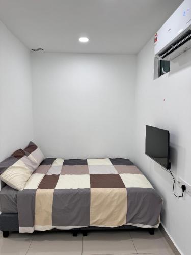 a bedroom with a bed and a flat screen tv at Famosa 2 Stay at Ong Kim Wee in Melaka