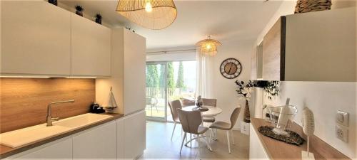 une cuisine avec un évier et une table avec des chaises dans l'établissement Appartement les Issambres, aux Issambres