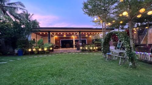 a backyard with a house with lights and a lawn at CD NATUREVIEW in Matangtubig