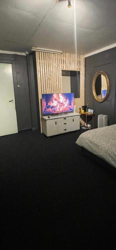 ein Schlafzimmer mit einem Flachbild-TV auf einer Kommode in der Unterkunft gms service in Lorenskog