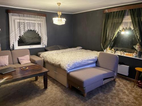 ein Schlafzimmer mit einem Bett, einem Sofa und einem Tisch in der Unterkunft gms service in Lorenskog