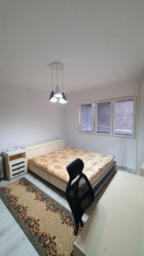 een slaapkamer met een bed en een stoel erin bij StaySavvy Residence in Štip