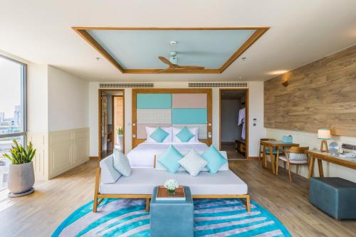 a bedroom with a bed with blue pillows at Fusion Suites Vung Tau in Vung Tau