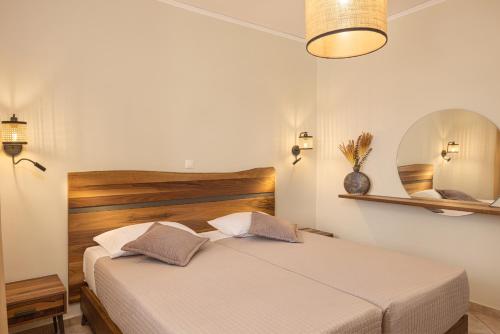 a bedroom with a bed and a mirror at PENNY LUXURY APARTMENTS in Kokkari