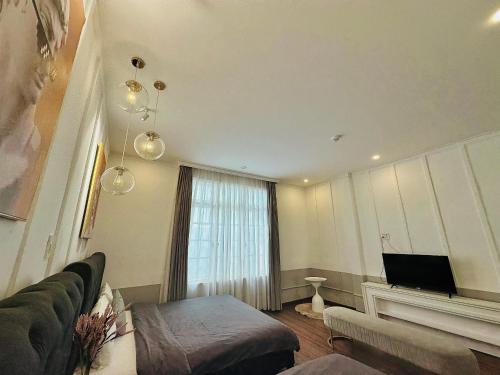 a living room with a couch and a television at RL Boutique Dalat in Da Lat