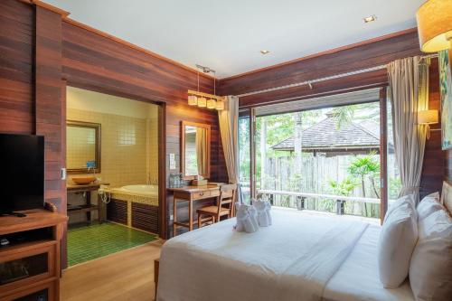 a bedroom with a large bed and a bathroom at GajaPuri Resort Koh Chang in Ko Chang