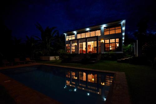 a house with a swimming pool at night at Private Villa at the Source of the Nile in Jinja