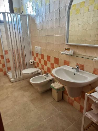 a bathroom with a sink and a toilet and a shower at Colledisisto Guest House & Restaurant in Pomarico