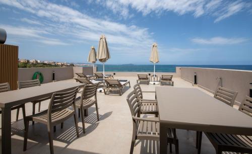 a patio with tables and chairs and umbrellas at ALPHA SUITES in Chania Town