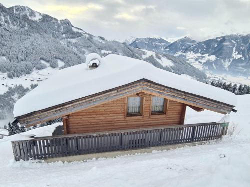 una cabaña de madera con nieve encima en Leitl Hütte ZILG100, en Zell am Ziller