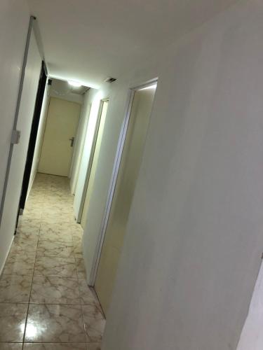 a hallway with white walls and a tiled floor at Al Majaz Partition & Rooms in Sharjah