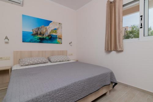 a bedroom with a bed with a painting on the wall at Sun & Sea in Laganas