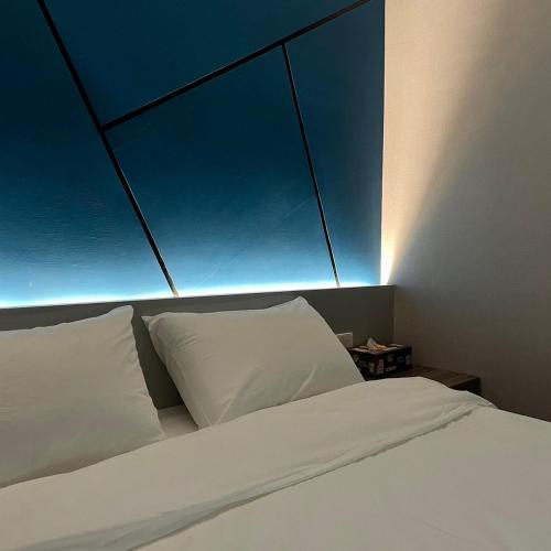 a bed with white pillows and a blue ceiling at 遇見 雲山居 in Fuli