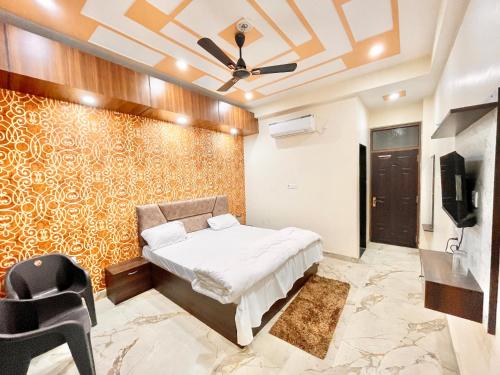 sypialnia z łóżkiem i wentylatorem sufitowym w obiekcie Hotel Sunayana Guest House ! Varanasi fully-Air-Conditioned hotel at prime location, near Kashi Vishwanath Temple, and Ganga ghat w mieście Waranasi