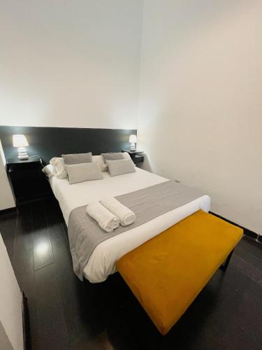 a bedroom with a large bed with white sheets and pillows at Carretas dúplex exterior izquierda in Madrid
