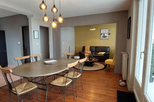 une salle à manger et un salon avec une table et des chaises dans l'établissement Evasion cotière à deux pas des plages, à Guidel