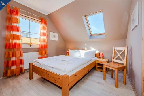 コルスヴァントにあるVillen am See - 4-Raum Häuser DHH Golfblickのベッドルーム1室(ベッド1台、窓、椅子付)