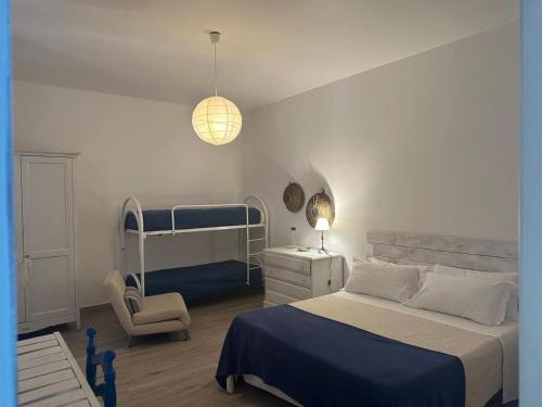 sypialnia z 2 łóżkami piętrowymi i krzesłem w obiekcie Civico 98 w mieście Milazzo