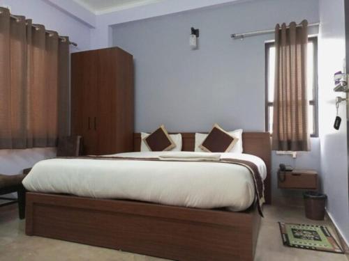 una camera da letto con un grande letto con lenzuola bianche di Hotel Prithvi Haridwar - Excellent Stay with Family, Parking Facilities a Haridwār