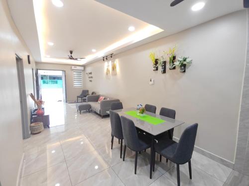 a living room with a table and chairs and a couch at 5 Blossom Loveu Homestay in Seremban