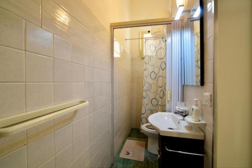 een badkamer met een wastafel, een toilet en een spiegel bij Mini casa in Salento in Cutrofiano