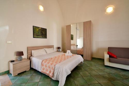 een slaapkamer met een bed, een stoel en een spiegel bij Mini casa in Salento in Cutrofiano