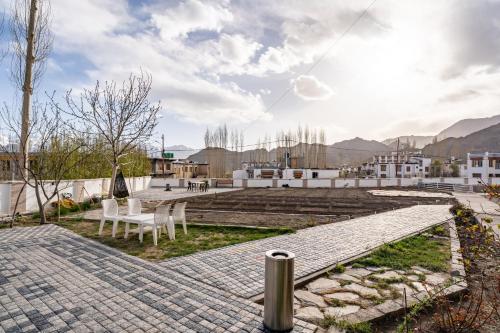 a patio with a table and chairs on top of a building at Adu's Eternal Comfort in Leh