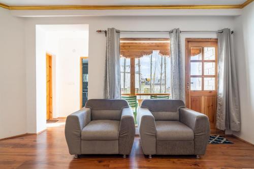 two chairs and a table in a living room at Adu's Eternal Comfort in Leh