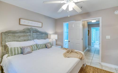 een slaapkamer met een groot wit bed en een plafondventilator bij Grand Caribbean 316 Community Pool Access Minutes to the ocean front in Perdido Key