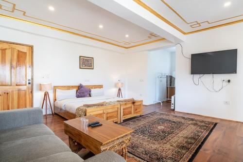 a bedroom with a bed and a couch and a tv at Adu's Eternal Comfort in Leh