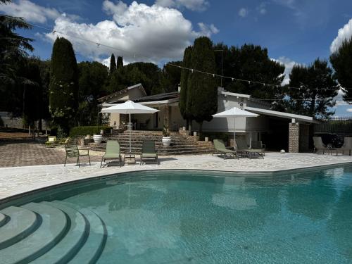 a swimming pool with chairs and umbrellas next to a house at Otto Apulia House B&B in Andria