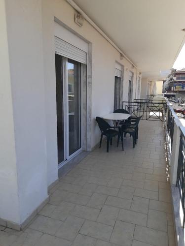a patio with a table and chairs on a building at Ilias Apartment in Hanioti
