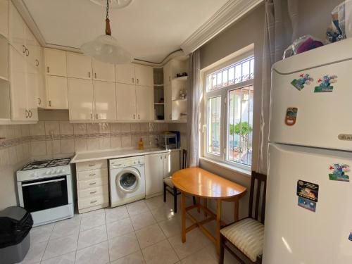 een keuken met een witte koelkast en een tafel bij Villa Sakarya in Side
