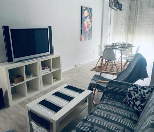 ein Wohnzimmer mit einem Sofa und einem TV in der Unterkunft Piso vacacional 7 minutos Cadiz in El Trocadero