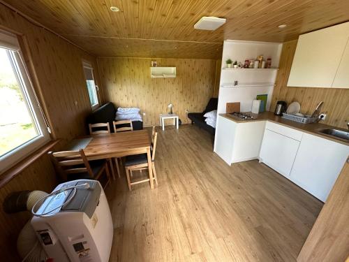 a small kitchen and dining area of a tiny house at Przystań Stare Kotlice 