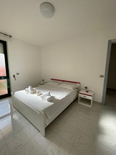 una camera bianca con letto e tavolo di Appartamenti al mare nel Salento a Torre Pali