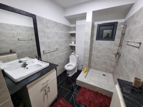 a bathroom with a sink and a toilet at Appartements MAXIMA in Libreville