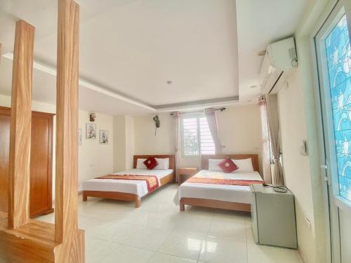 een slaapkamer met 2 bedden en een raam bij Phú Hồng 1 Hotel in Sầm Sơn
