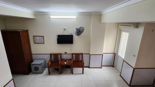 een kamer met een tafel en een tv aan de muur bij Phú Hồng 1 Hotel in Sầm Sơn