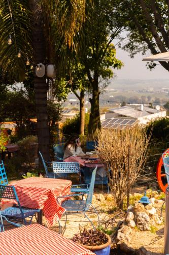 a woman sitting at a table with tables and chairs at וילה תהילה המחודש - The new Villa Tehila in Rosh Pinna
