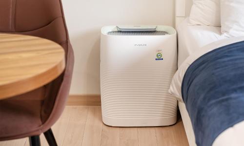 a small white heater in a room next to a bed at CM Park Hotel in Andong