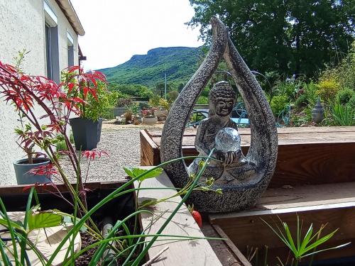 a statue of a buddha sitting on a bench at La guitoune in Laroque