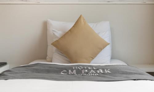 a bed with a hotel cnc park pillow on it at CM Park Hotel in Andong