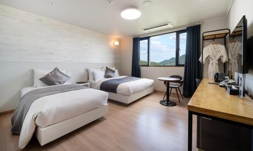 a hotel room with two beds and a television at CM Park Hotel in Andong
