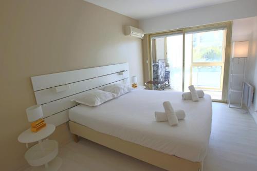 une chambre avec un lit blanc avec deux serviettes dessus dans l'établissement Apartment Seaside, à Cannes