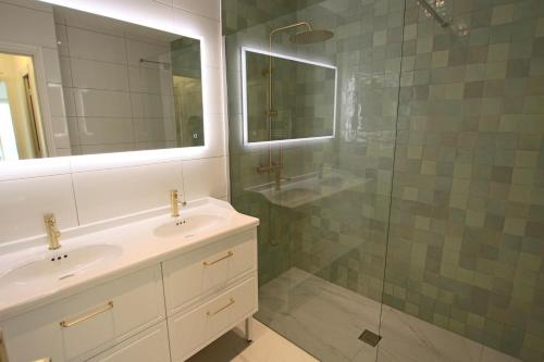 une salle de bain avec un lavabo et une douche en verre dans l'établissement Apartment Seaside, à Cannes